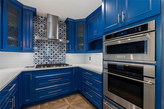 225 Fisher Ave, White Plains, NY 10606 - kitchen featuring blue cabinets, wall chimney exhaust hood, appliances with stainless steel finishes, and light countertops