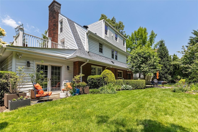 225 Fisher Ave, White Plains, NY 10606 - back of house with a gambrel roof, a yard, a chimney, brick siding, and a shingled roof
