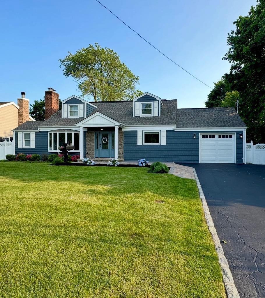 46 Purdy Ln, Amityville, NY 11795 - view of front facade featuring a garage, driveway, and a shingled roof