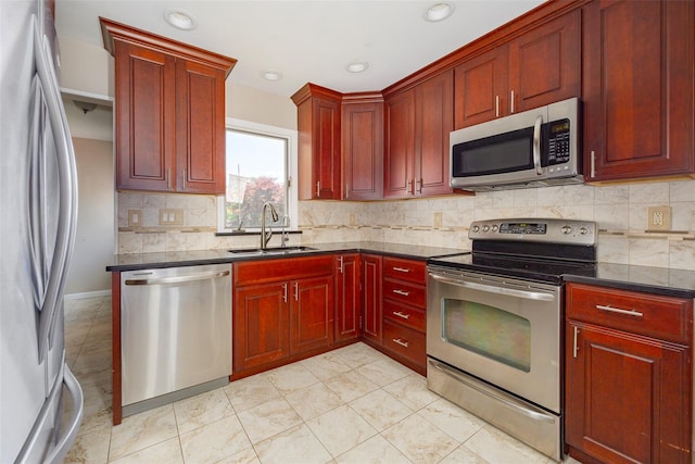 18 Lorraine Blvd, Poughkeepsie, NY 12603 - kitchen with stainless steel appliances, a sink, reddish brown cabinets, decorative backsplash, and recessed lighting