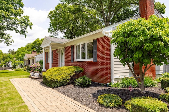18 Lorraine Blvd, Poughkeepsie, NY 12603 - view of front facade featuring brick siding, a front yard, an attached garage, and a chimney