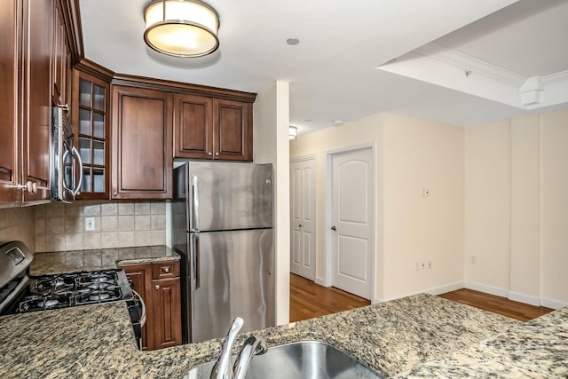 150-31 12th Ave Unit 112, Whitestone, NY 11357 - kitchen with appliances with stainless steel finishes, dark stone countertops, backsplash, and crown molding
