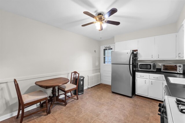 5 Fairview Ave, New Paltz, NY 12561 - kitchen with stainless steel appliances, radiator, dark countertops, a ceiling fan, and white cabinetry