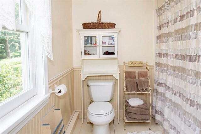 184 Sawchuck Rd, Millerton, NY 12546 - bathroom with toilet, tile patterned floors, healthy amount of natural light, a shower with curtain, and a wainscoted wall