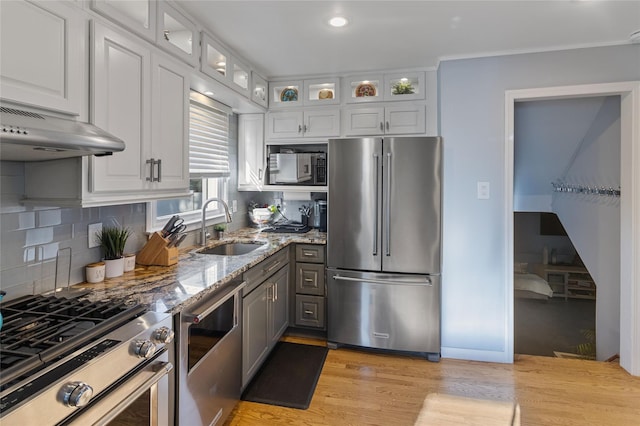 22 Martha St, Freeport, NY 11520 - kitchen featuring appliances with stainless steel finishes, a sink, light stone countertops, light wood-type flooring, and white cabinetry