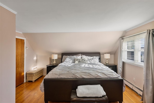 22 Martha St, Freeport, NY 11520 - bedroom with a baseboard heating unit, light wood-style flooring, vaulted ceiling, crown molding, and baseboards