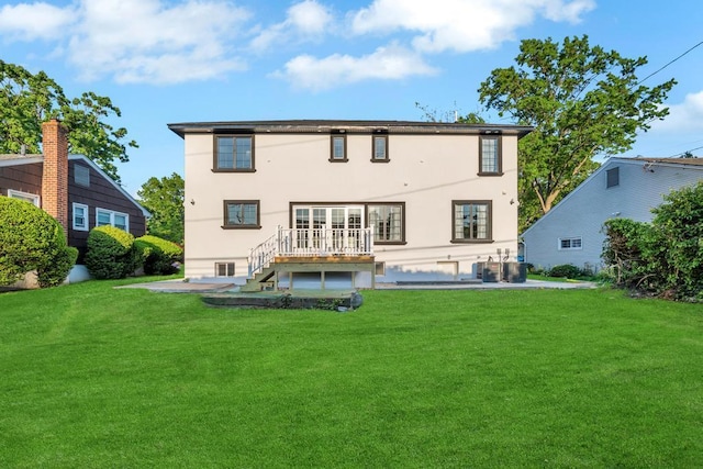22 Elderberry Ln, Valley Stream, NY 11581 - rear view of property with a yard, stucco siding, and a wooden deck