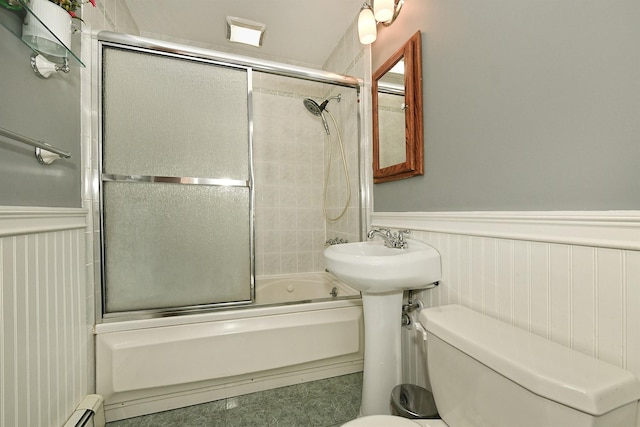 29 Andrew Ln, Levittown, NY 11756 - bathroom featuring wainscoting, bath / shower combo with glass door, toilet, and baseboard heating