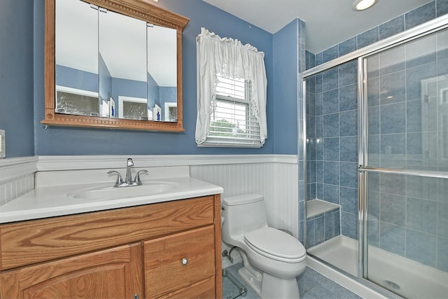 29 Andrew Ln, Levittown, NY 11756 - bathroom featuring vanity, toilet, wainscoting, tile patterned floors, and a shower stall