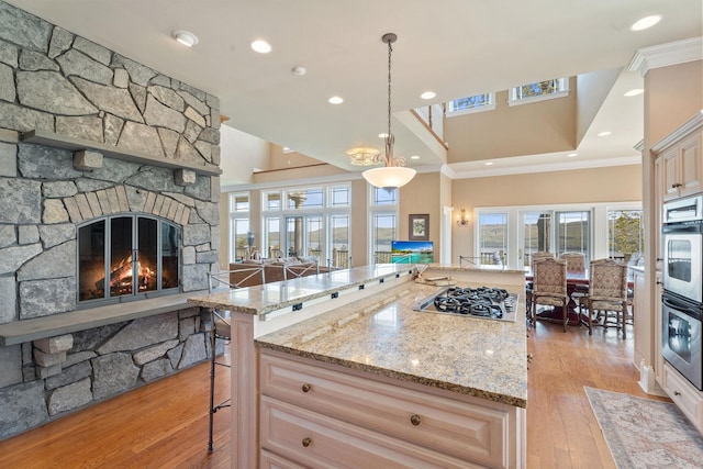 436 Steuben St, Call Listing Agent, NY 14891 - kitchen featuring crown molding, stainless steel gas cooktop, a fireplace, light wood-type flooring, and healthy amount of natural light