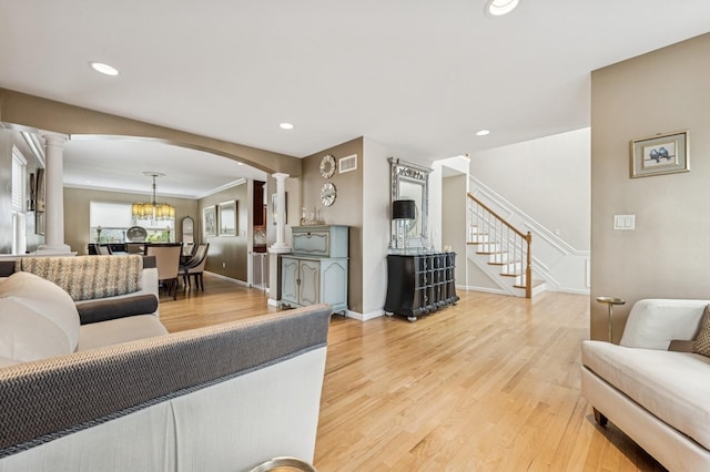 287 Atlantic Ave, Massapequa Park, NY 11762 - living room featuring ornate columns, stairs, light wood finished floors, arched walkways, and recessed lighting