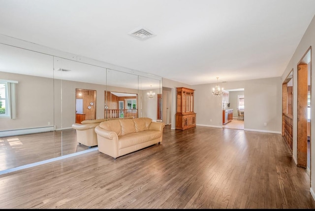 1 Leeward Ln, Commack, NY 11725 - living room with a chandelier, baseboard heating, and wood finished floors