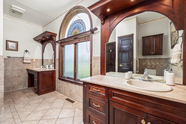 204 Moore Rd, Germantown, NY 12526 - bathroom with tile walls, two vanities, a wainscoted wall, tile patterned flooring, and ornamental molding