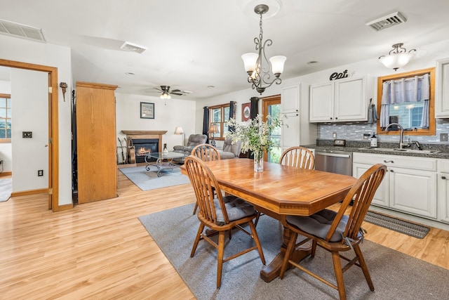 204 Moore Rd, Germantown, NY 12526 - dining space with a glass covered fireplace, a ceiling fan, light wood-style floors, and baseboards