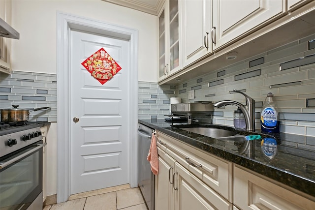 86-04 Grand Ave Unit 4D, Elmhurst, NY 11373 - kitchen featuring appliances with stainless steel finishes, a sink, backsplash, dark stone counters, and glass insert cabinets