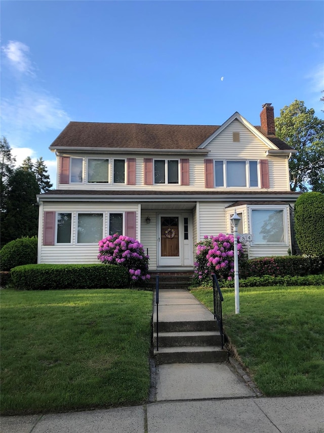 84 Hillcrest Ave, Manhasset, NY 11030 - traditional-style house featuring a chimney and a front yard