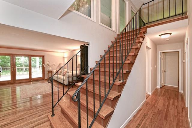 2 Wooded Ct, Lloyd Harbor, NY 11743 - staircase with wood finished floors, baseboards, and a high ceiling