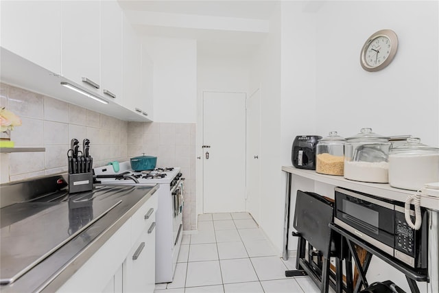 2 Fordham Hill Oval Unit 2F, Bronx, NY 10468 - kitchen with white range with gas cooktop, light tile patterned flooring, white cabinets, and stainless steel microwave