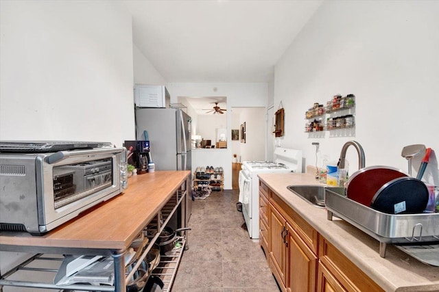 616 E 9th St Unit 2W, New York Manhattan, NY 10009 - kitchen featuring white range with gas stovetop, a sink, brown cabinetry, light countertops, and a ceiling fan