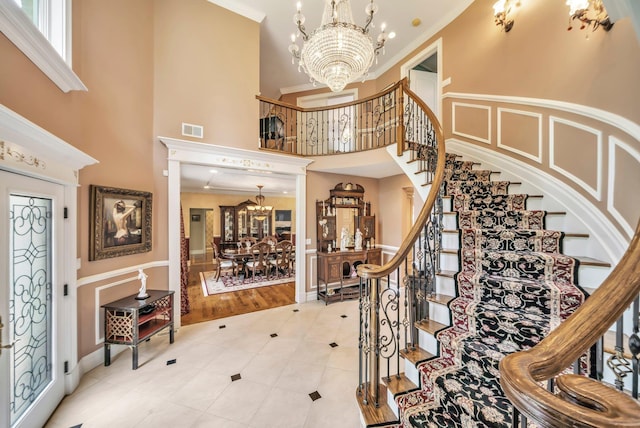 13 Locust Ln, Upper Brookville, NY 11545 - foyer featuring a chandelier, ornamental molding, light tile patterned floors, stairs, and a high ceiling