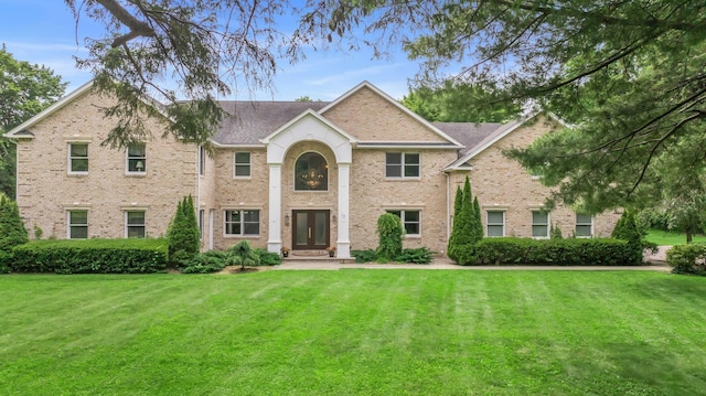13 Locust Ln, Upper Brookville, NY 11545 - view of front facade featuring a front lawn, brick siding, roof with shingles, and french doors