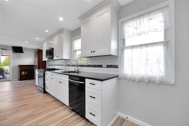 3717 Somerset Dr, Seaford, NY 11783 - kitchen with dishwashing machine, stainless steel gas range, a sink, dark countertops, and light wood-style floors