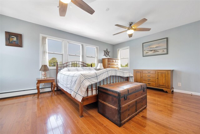 3717 Somerset Dr, Seaford, NY 11783 - bedroom featuring baseboard heating, light wood-style floors, baseboards, and ceiling fan