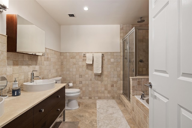 260 W Broadway Unit 2G, Long Beach, NY 11561 - bathroom featuring a stall shower, double vanity, toilet, tile walls, and tile patterned floors