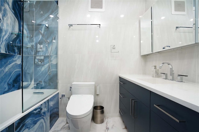 200 E 61st St Unit 19De, New York Manhattan, NY 10065 - bathroom with vanity, a combined bath / shower with marble appearance, tile walls, toilet, and marble look tile flooring