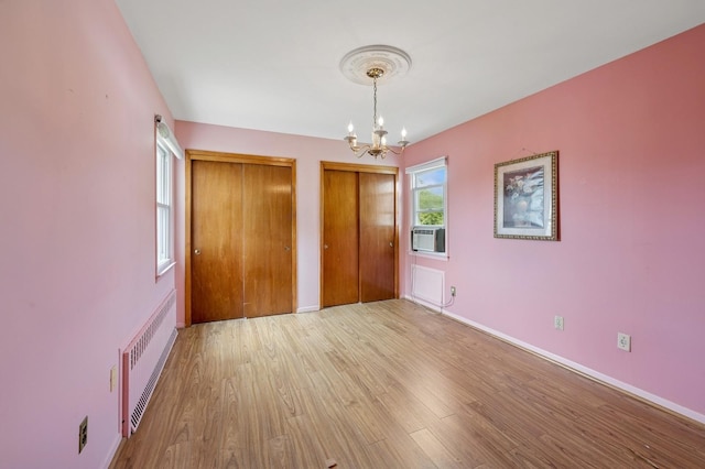 151AKA149 Stone Ave, Yonkers, NY 10701 - unfurnished bedroom featuring two closets, a chandelier, wood finished floors, radiator, and cooling unit