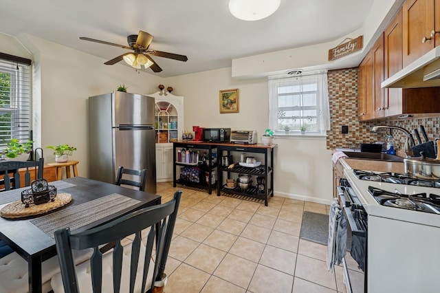 151AKA149 Stone Ave, Yonkers, NY 10701 - kitchen with freestanding refrigerator, white gas stove, brown cabinets, ceiling fan, and healthy amount of natural light