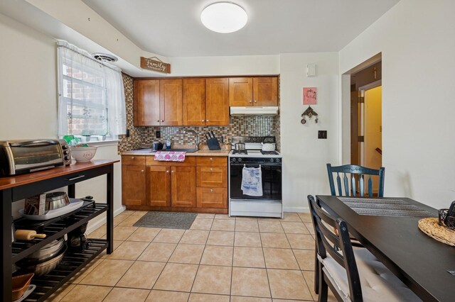 151AKA149 Stone Ave, Yonkers, NY 10701 - kitchen featuring white stove, under cabinet range hood, brown cabinets, tasteful backsplash, and light tile patterned floors