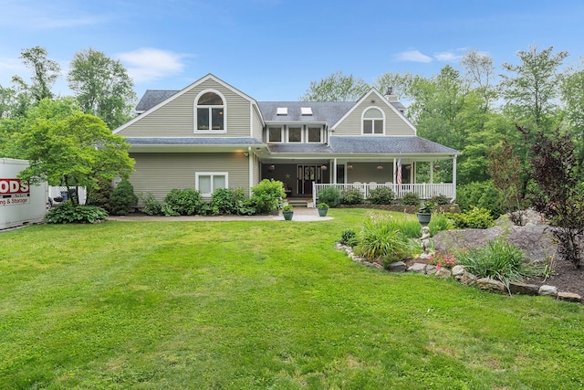 83 Mcdonald Rd, Ossining, NY 10562 - view of front facade featuring covered porch, a chimney, a front yard, and a shingled roof