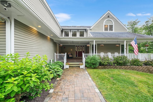 83 Mcdonald Rd, Ossining, NY 10562 - view of exterior entry with a lawn, a porch, and roof with shingles