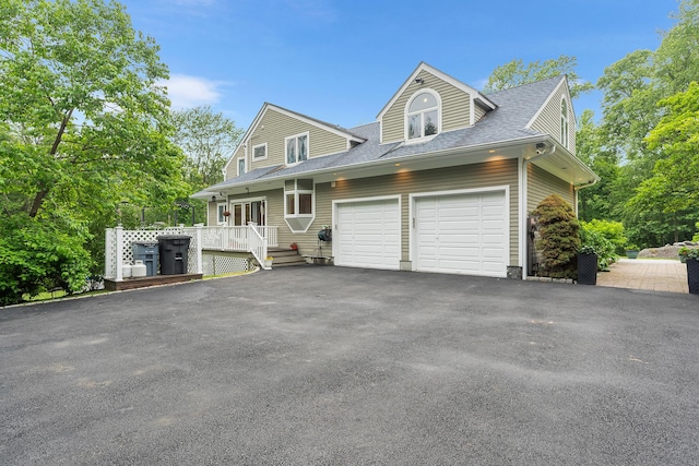 83 Mcdonald Rd, Ossining, NY 10562 - view of front of house with an attached garage, asphalt driveway, roof with shingles, and a wooden deck