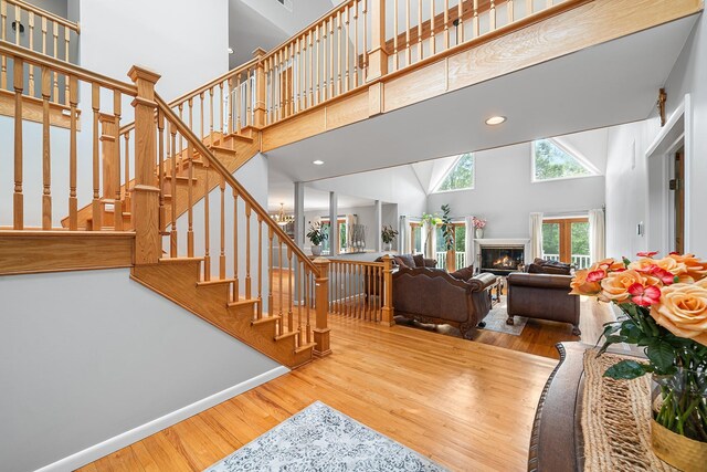 83 Mcdonald Rd, Ossining, NY 10562 - stairs with a towering ceiling, wood finished floors, a glass covered fireplace, and recessed lighting