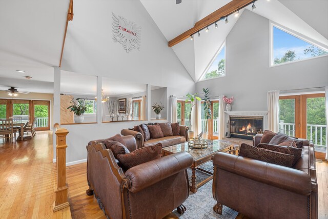 83 Mcdonald Rd, Ossining, NY 10562 - living room featuring rail lighting, light wood finished floors, a glass covered fireplace, ceiling fan, and high vaulted ceiling