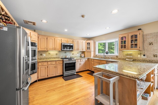 83 Mcdonald Rd, Ossining, NY 10562 - kitchen with stainless steel appliances, a peninsula, light wood finished floors, decorative backsplash, and recessed lighting