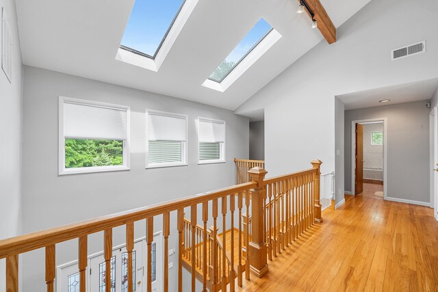 83 Mcdonald Rd, Ossining, NY 10562 - hallway with an upstairs landing, a skylight, light wood-type flooring, track lighting, and high vaulted ceiling