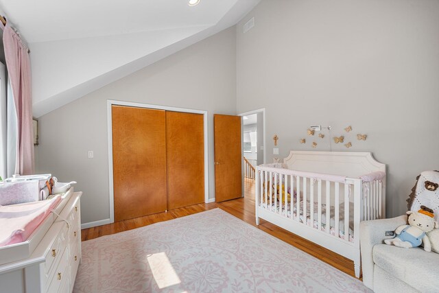 83 Mcdonald Rd, Ossining, NY 10562 - bedroom featuring light wood-style floors, a closet, a nursery area, and high vaulted ceiling