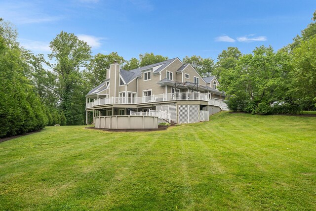 83 Mcdonald Rd, Ossining, NY 10562 - rear view of property featuring a wooden deck, a chimney, and a lawn