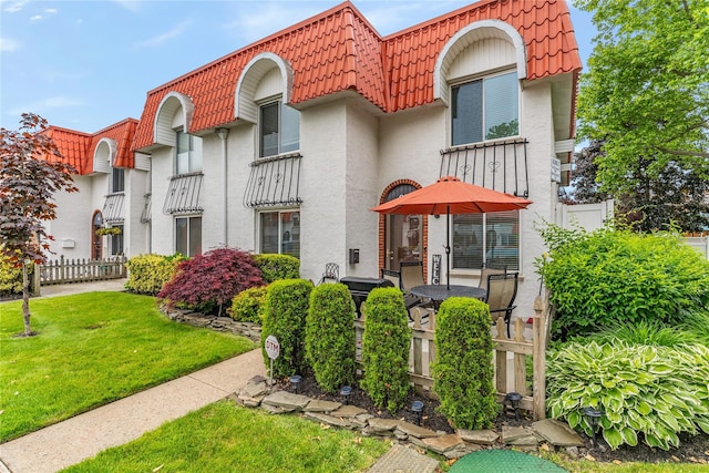 62 Alhambra Dr, Oceanside, NY 11572 - view of front of house featuring mansard roof, stucco siding, and a tiled roof
