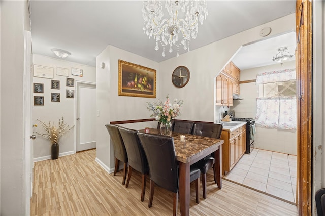 1363 Noble Ave, Bronx, NY 10472 - dining room featuring a chandelier, light wood-style floors, arched walkways, and baseboards