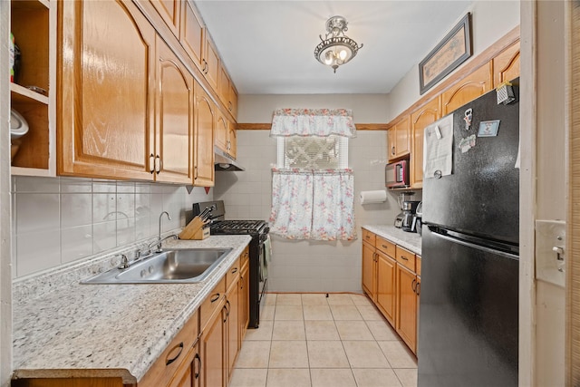 1363 Noble Ave, Bronx, NY 10472 - kitchen featuring freestanding refrigerator, black range with gas stovetop, a sink, light countertops, and tile walls