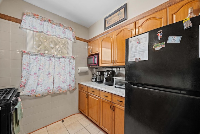 1363 Noble Ave, Bronx, NY 10472 - kitchen with freestanding refrigerator, tile walls, range with gas stovetop, light tile patterned floors, and brown cabinets
