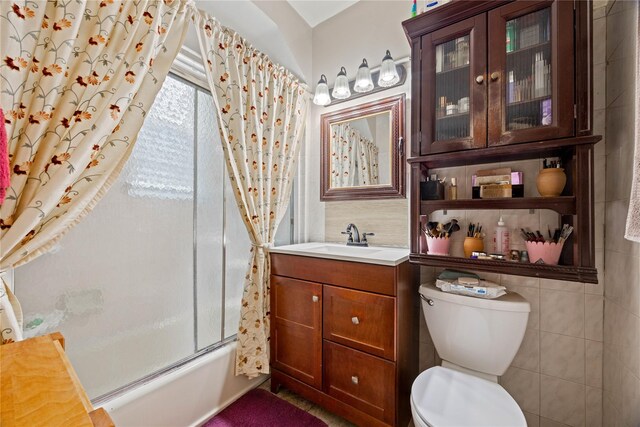 1363 Noble Ave, Bronx, NY 10472 - full bathroom with toilet, vanity, combined bath / shower with glass door, and tile walls