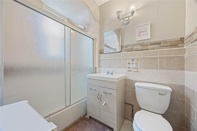 1363 Noble Ave, Bronx, NY 10472 - bathroom featuring vanity, toilet, tile walls, and shower / bath combination with glass door