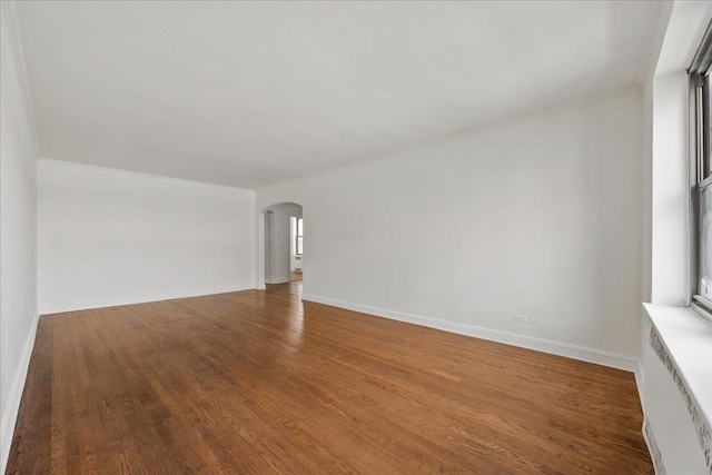 98-120 Queens Blvd Unit 5G, Rego Park, NY 11374 - spare room featuring arched walkways, wood finished floors, and baseboards