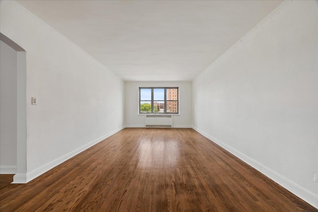 98-120 Queens Blvd Unit 5G, Rego Park, NY 11374 - spare room featuring radiator, wood finished floors, baseboards, and crown molding
