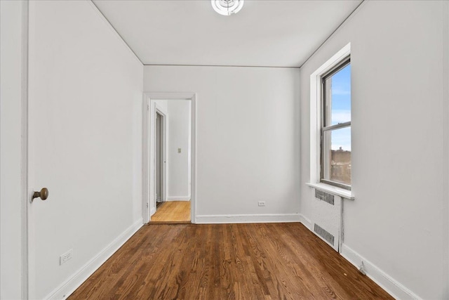 98-120 Queens Blvd Unit 5G, Rego Park, NY 11374 - spare room featuring radiator, dark wood-style floors, and baseboards